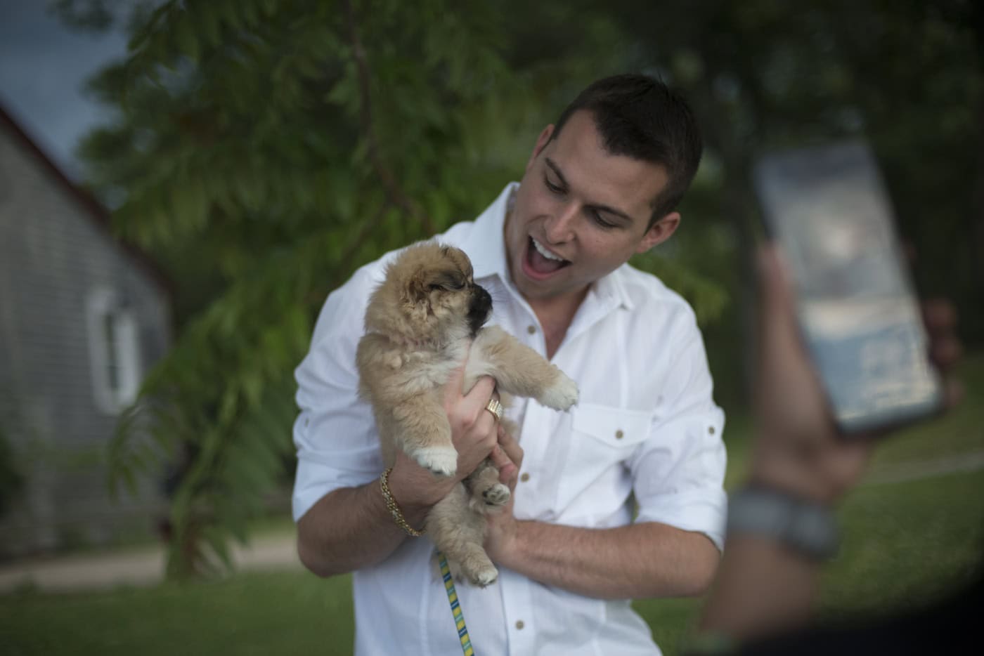 Matt Fraser from the new show 'The Frasers + ONE' holds a puppy and smiles 