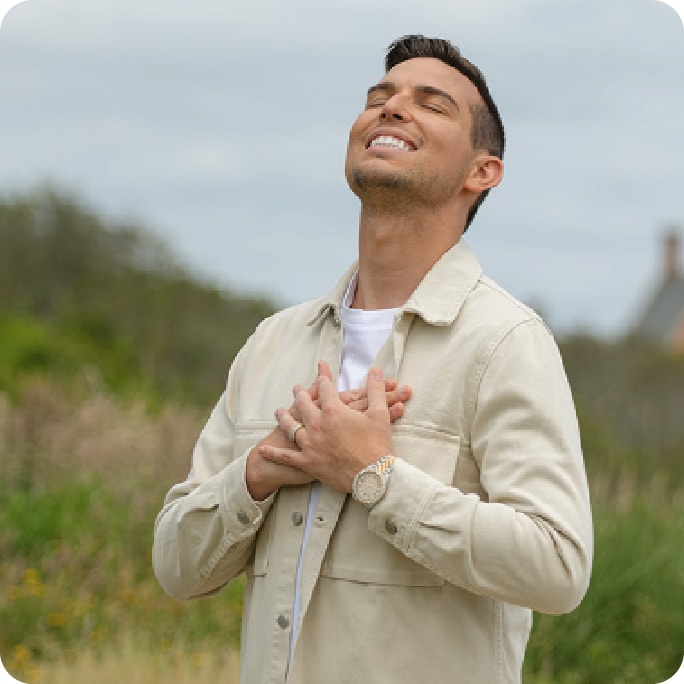 Matt standing by the oceanside with hands on his heart