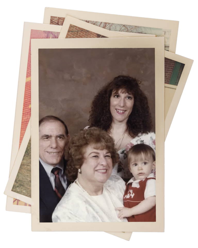 A vintage family photo featuring Matt Fraser, a woman, an older woman holding a baby, and another standing woman. They are posing in front of a brown backdrop. Other photographs are partially visible behind.