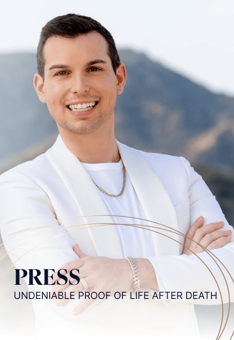 Matt Fraser, in a white suit and chain necklace, smiles with arms crossed. Text reads "PRESS: Undeniable Proof of Life After Death." The background features a mountainous landscape.